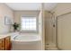 Bright bathroom with jacuzzi tub and seperate shower featuring a window for natural light and modern fixtures at 5404 Onyx Mill Ct, Raleigh, NC 27616