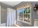 Bright bathroom with a shower and tub featuring a window for natural light and a decorative valance at 5404 Onyx Mill Ct, Raleigh, NC 27616