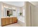 Bathroom featuring dual sinks, a large mirror, jacuzzi tub, and separate shower with natural light at 5404 Onyx Mill Ct, Raleigh, NC 27616