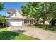 Traditional home showcasing a two-car garage, inviting front porch, and a long driveway at 5404 Onyx Mill Ct, Raleigh, NC 27616