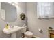 Well-lit half bathroom with a pedestal sink, decorative mirror, and classic fixtures at 5404 Onyx Mill Ct, Raleigh, NC 27616