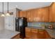 Kitchen showcases ample wood cabinetry, stone backsplash, black appliances, and durable countertops at 5404 Onyx Mill Ct, Raleigh, NC 27616