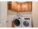 This laundry room features overhead storage with a modern washer and dryer and a simple door at 5404 Onyx Mill Ct, Raleigh, NC 27616