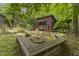 Outdoor view of a cabin with a fire pit and bench seating in a woodsy setting at 5604 Hideaway Dr, Chapel Hill, NC 27516