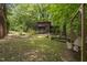 Outdoor view of a cabin with a fire pit and swing bench seating in a woodsy setting at 5604 Hideaway Dr, Chapel Hill, NC 27516