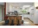 Eat-in kitchen with light colored cabinets, modern fixtures, breakfast bar and wood floors at 5604 Hideaway Dr, Chapel Hill, NC 27516