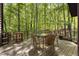 Outdoor dining area on a wooden deck surrounded by beautiful green forest at 5604 Hideaway Dr, Chapel Hill, NC 27516