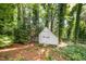 Storage shed nestled in a wooded backyard providing a tranquil and private setting at 5804 Heatherbrook Cir, Raleigh, NC 27612