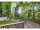 Wooden deck overlooking a lush, wooded backyard with mature trees and a storage shed at 5804 Heatherbrook Cir, Raleigh, NC 27612
