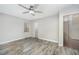 Neutral bedroom with gray wood-look floors, a ceiling fan, and natural light at 5804 Heatherbrook Cir, Raleigh, NC 27612