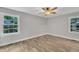 Bedroom featuring new wood floors, ceiling fan, and large windows at 5804 Heatherbrook Cir, Raleigh, NC 27612