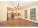 The dining area adjacent to the kitchen features hardwood floors, a decorative chandelier, and a walkout to the backyard at 5804 Heatherbrook Cir, Raleigh, NC 27612
