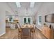 Open-concept dining area with hardwood floors, skylights, and French doors leading to outdoor space at 5804 Heatherbrook Cir, Raleigh, NC 27612