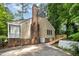Side view of house exterior featuring a brick chimney, a ramp and a well manicured lawn at 5804 Heatherbrook Cir, Raleigh, NC 27612