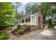 Exterior view of a charming home with a covered porch, brick accents, side entry garage and a lush treed lot at 5804 Heatherbrook Cir, Raleigh, NC 27612