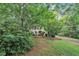 Home exterior framed by lush trees, featuring a well-maintained front lawn and classic architecture at 5804 Heatherbrook Cir, Raleigh, NC 27612