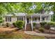 Inviting single Gathering home featuring a classic covered porch with brick base, complemented by lush greenery and brick stairs at 5804 Heatherbrook Cir, Raleigh, NC 27612