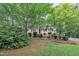 Front exterior view of home surrounded by lush greenery and a brick foundation at 5804 Heatherbrook Cir, Raleigh, NC 27612