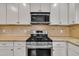 Close up of kitchen with stainless steel appliances, granite countertops, and tile backsplash at 5804 Heatherbrook Cir, Raleigh, NC 27612