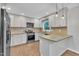 Modern kitchen with stainless steel appliances, white cabinets, and granite countertops at 5804 Heatherbrook Cir, Raleigh, NC 27612