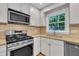 Kitchen showcasing stainless steel appliances, granite countertops, and white cabinetry at 5804 Heatherbrook Cir, Raleigh, NC 27612
