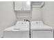 Bright laundry room with washer and dryer, upper cabinets for storage at 5804 Heatherbrook Cir, Raleigh, NC 27612