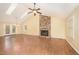 Spacious living room featuring hardwood floors, a skylight, brick fireplace and neutral paint, brightened by natural light at 5804 Heatherbrook Cir, Raleigh, NC 27612