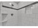 Close-up of white tiled shower with black accent stripe and built-in shelf at 5804 Heatherbrook Cir, Raleigh, NC 27612