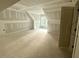 Unfinished attic with dormer windows offering natural light and primed walls and doors ready for paint at 60 Stream View Way, Spring Hope, NC 27882