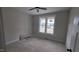 A well lit bedroom features neutral walls, a ceiling fan, and a large window at 60 Stream View Way, Spring Hope, NC 27882