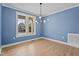 Well-lit dining area with hardwood floors, a modern chandelier, and views of the front yard at 60 Stream View Way, Spring Hope, NC 27882