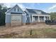 Charming new two-story home with blue siding, covered porch and black accents in a wooded setting at 60 Stream View Way, Spring Hope, NC 27882