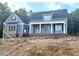 Striking new construction home with blue siding, brick accents, and a covered front porch at 60 Stream View Way, Spring Hope, NC 27882