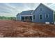 Exterior elevation of the home featuring blue siding, dark roof and unfinished landscaping at 60 Stream View Way, Spring Hope, NC 27882
