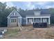 Charming new two-story home with blue siding, covered porch and black accents in a wooded setting at 60 Stream View Way, Spring Hope, NC 27882
