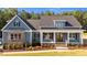 Inviting exterior of a two-story home, featuring blue siding, a welcoming front porch, and professional landscaping at 60 Stream View Way, Spring Hope, NC 27882
