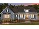 Charming exterior of a blue home with brick accents, landscaped yard, and inviting front porch at 60 Stream View Way, Spring Hope, NC 27882