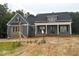 Lovely home showcasing blue siding, a brick foundation, and a welcoming front porch with classic columns at 60 Stream View Way, Spring Hope, NC 27882