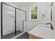 Modern bathroom boasts a glass-enclosed shower, marble-look tiles, and a window at 60 Stream View Way, Spring Hope, NC 27882