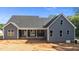 Back of the house with gray siding, a covered porch, and an unfinished yard at 60 Stream View Way, Spring Hope, NC 27882