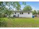 Spacious backyard featuring a well-kept lawn and a partial fence and the home's exterior with multiple windows at 601 Longfellow St, Fuquay Varina, NC 27526