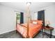 Bedroom featuring a four-poster bed, wood floors, and natural light at 601 Longfellow St, Fuquay Varina, NC 27526