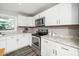 Updated kitchen features white cabinets, modern appliances, and granite countertops at 601 Longfellow St, Fuquay Varina, NC 27526