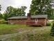 Brick home exterior with small deck and spacious backyard, offering outdoor living and entertainment at 605 Mace Rd, Mebane, NC 27302
