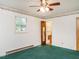 Bright bedroom with ceiling fan, green carpet, and en-suite bathroom, offering comfort and privacy at 605 Mace Rd, Mebane, NC 27302