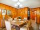 Warm dining room with wood paneling, a rustic table, and seating for six, creating a welcoming space for gatherings at 605 Mace Rd, Mebane, NC 27302