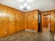 Cozy dining area with wood paneling, classic chandelier, and neutral tile flooring, creating a warm ambiance at 605 Mace Rd, Mebane, NC 27302