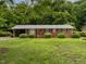 Charming single-story brick home with a well-manicured lawn and mature trees, providing a serene and inviting curb appeal at 605 Mace Rd, Mebane, NC 27302