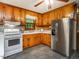 Functional kitchen with wood cabinets, white appliances, and ample counter space, ready for culinary adventures at 605 Mace Rd, Mebane, NC 27302