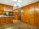 Open kitchen featuring warm wood paneling, a breakfast bar, and stainless steel appliances for modern functionality at 605 Mace Rd, Mebane, NC 27302